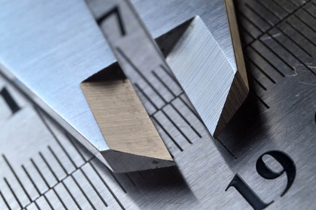 Close up view of metal calipers on a ruler.