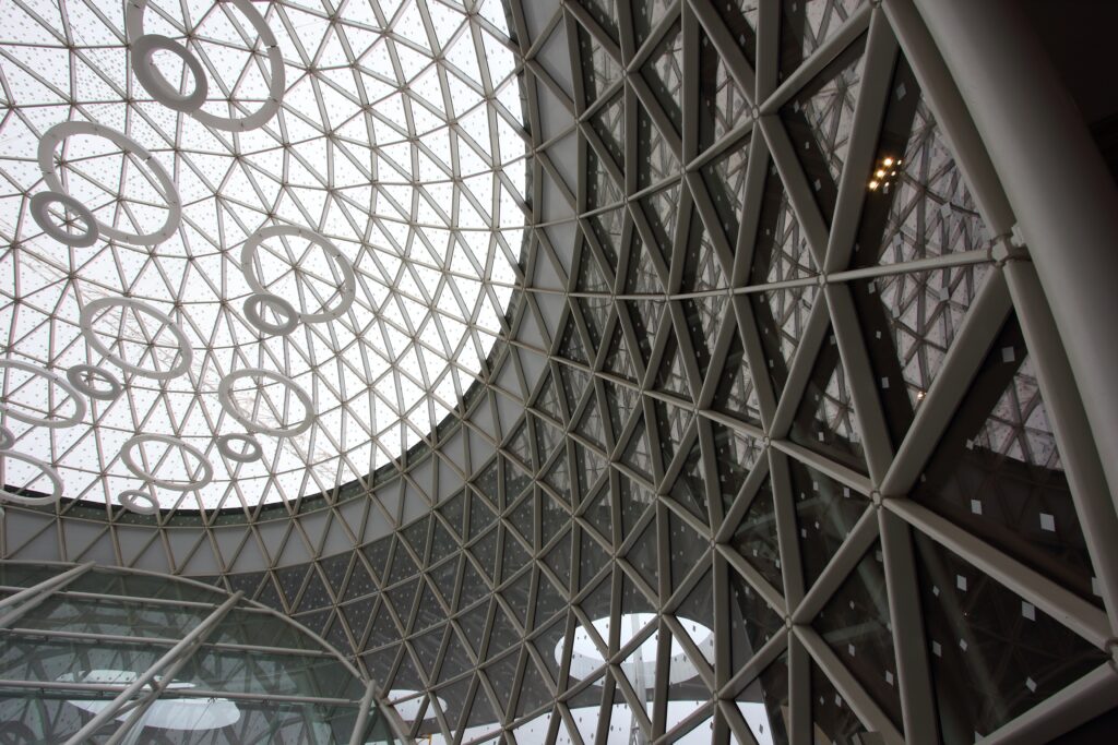 Interior view of the glass dome of a vast modern atrium.