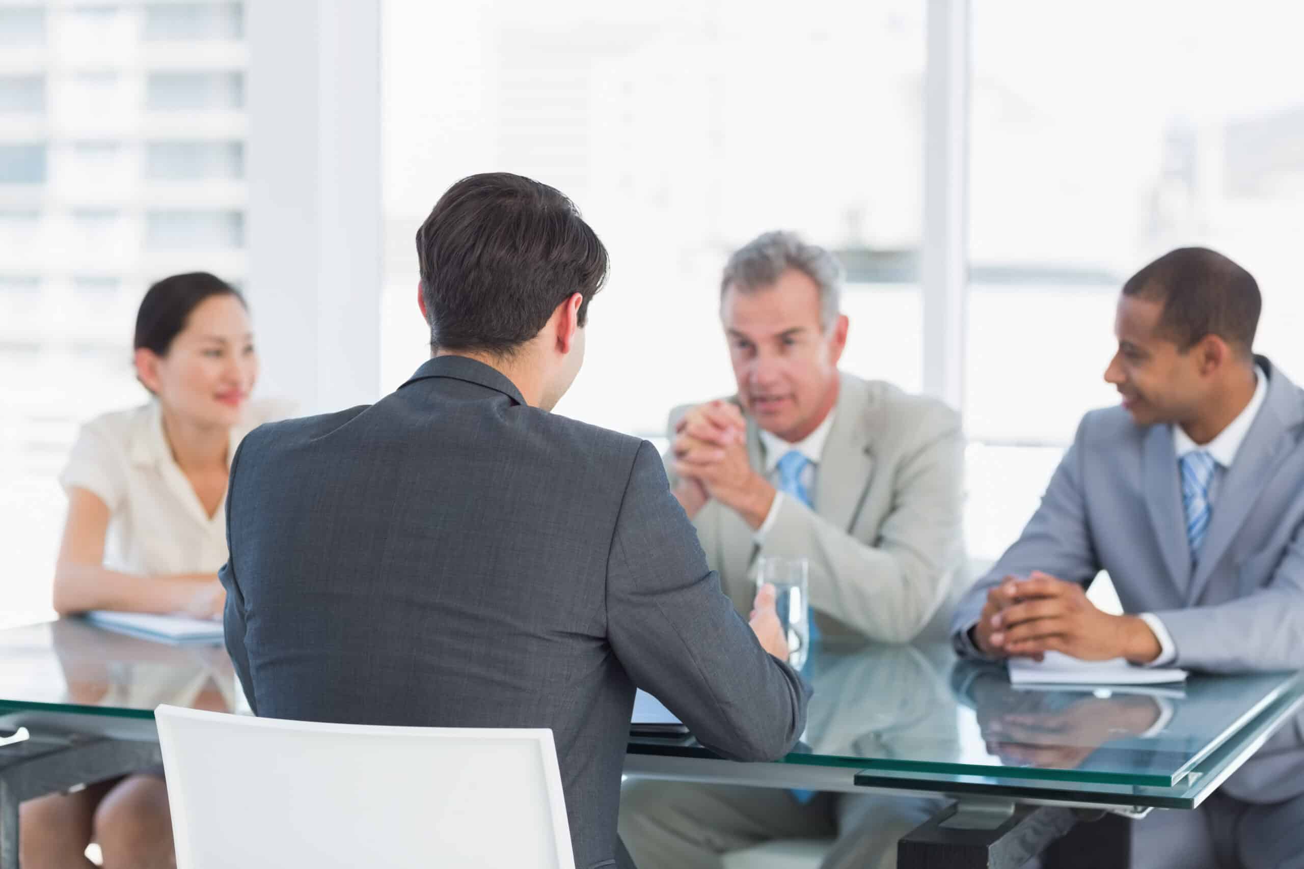 Business man sitting at conference table advises client and his team